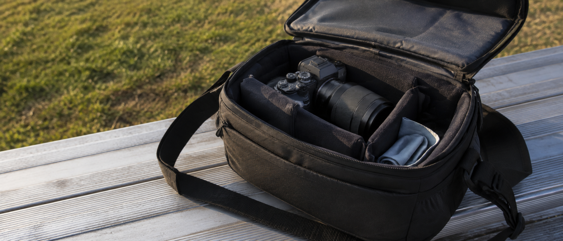 Unbranded camera supported inside an open padded bag on an empty field-side bench